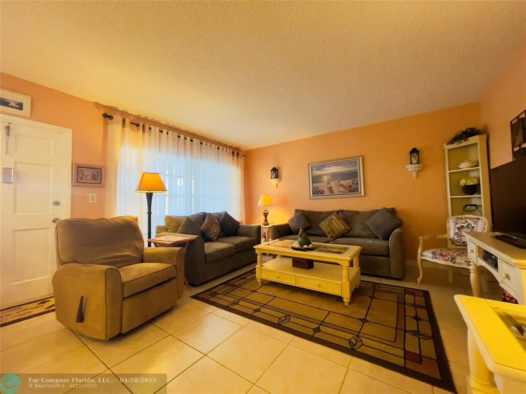651 Pine Drive, Unit 207 Pompano Beach, FL 33060 - Photo 8 of 18 a living room with furniture and a flat screen tv