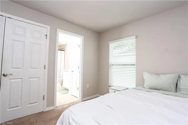 a large bed sitting in a bedroom next to a window