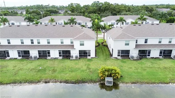 an aerial view of a house with a yard and lake view
