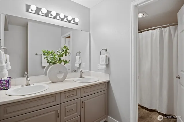 a view of washer and dryer with bathroom in the background