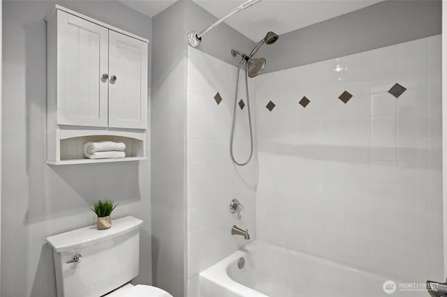 a bedroom with a bed and a lamp on dresser