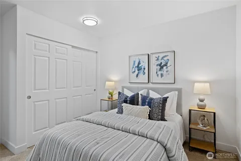 a bedroom with a bed and a lamp on the dresser