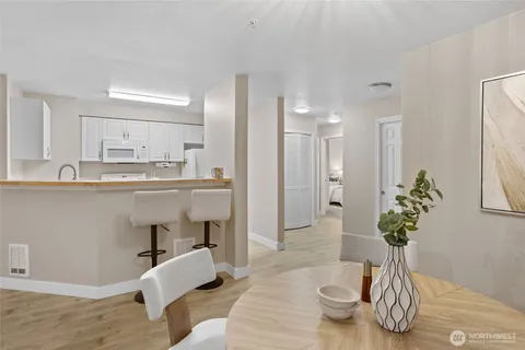 a dining room with wooden floor a chandelier a glass table and chairs