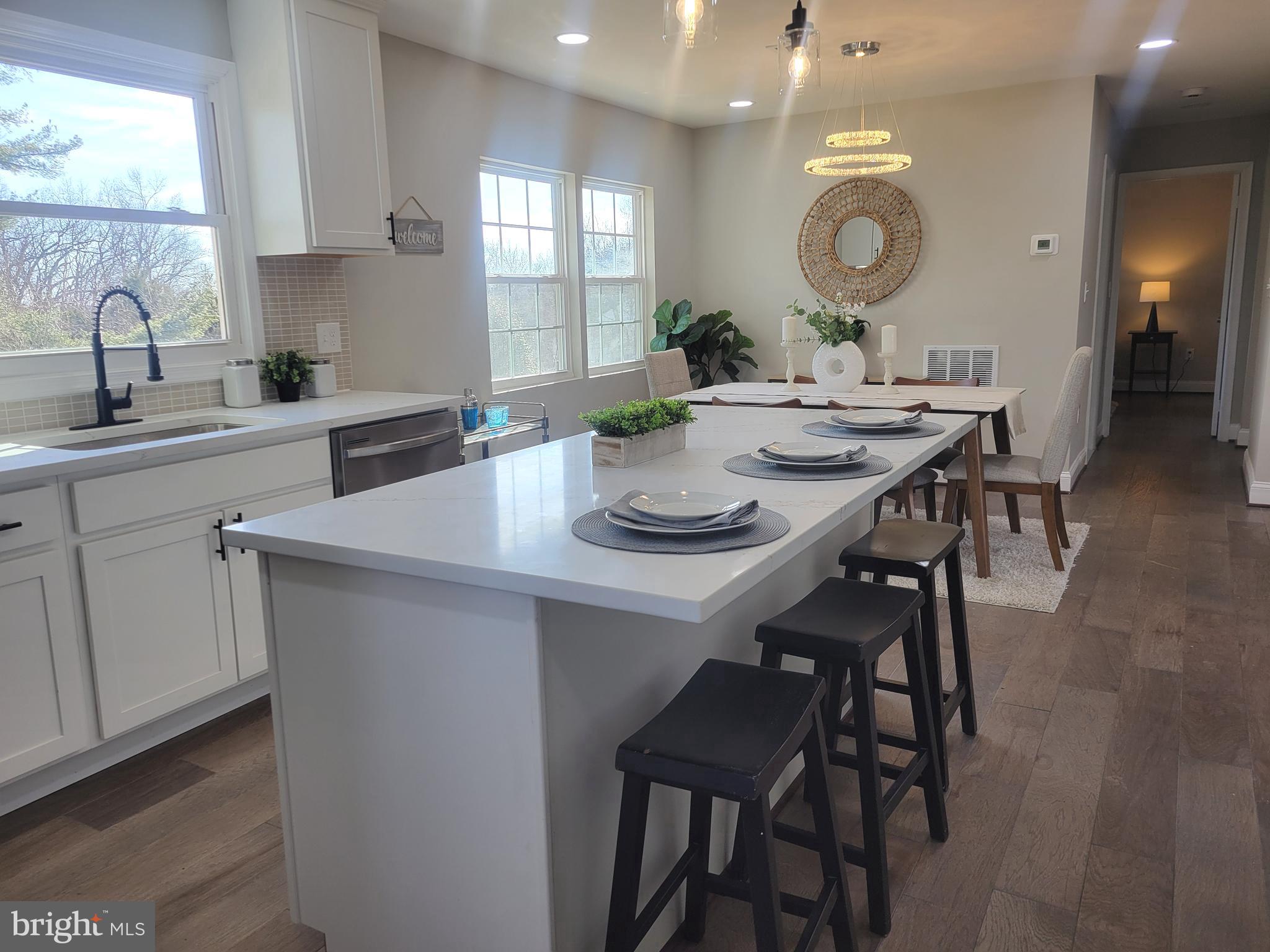 5303 Emory Road Upperco, MD 21155 - Photo 18 of 33 a kitchen with a dining table chairs and white cabinets with wooden floor
