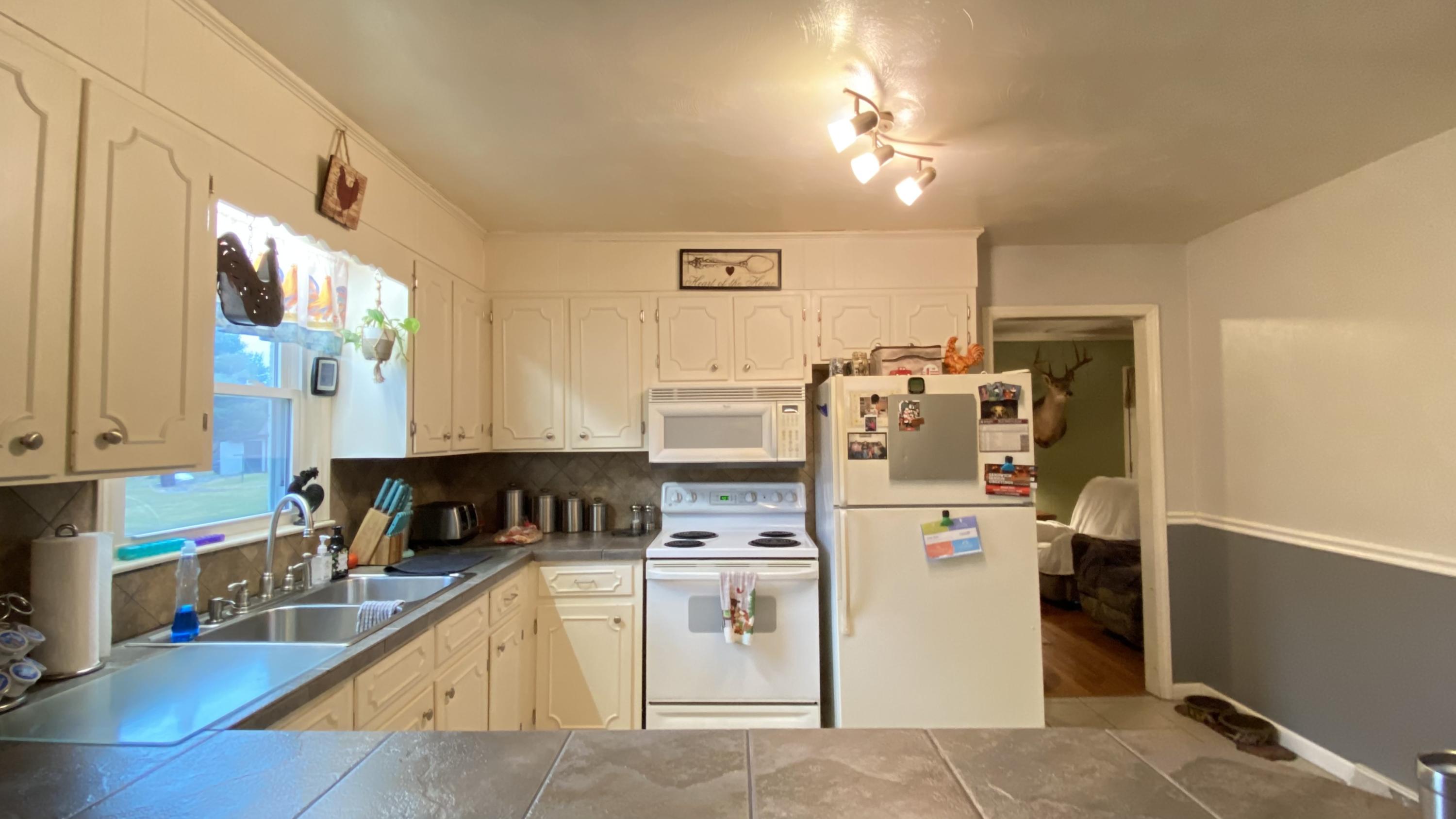 1171 Rock Spring Road Goodview, VA 24095 - Photo 11 of 29 a kitchen that has a lot of white cabinets and stainless steel appliances