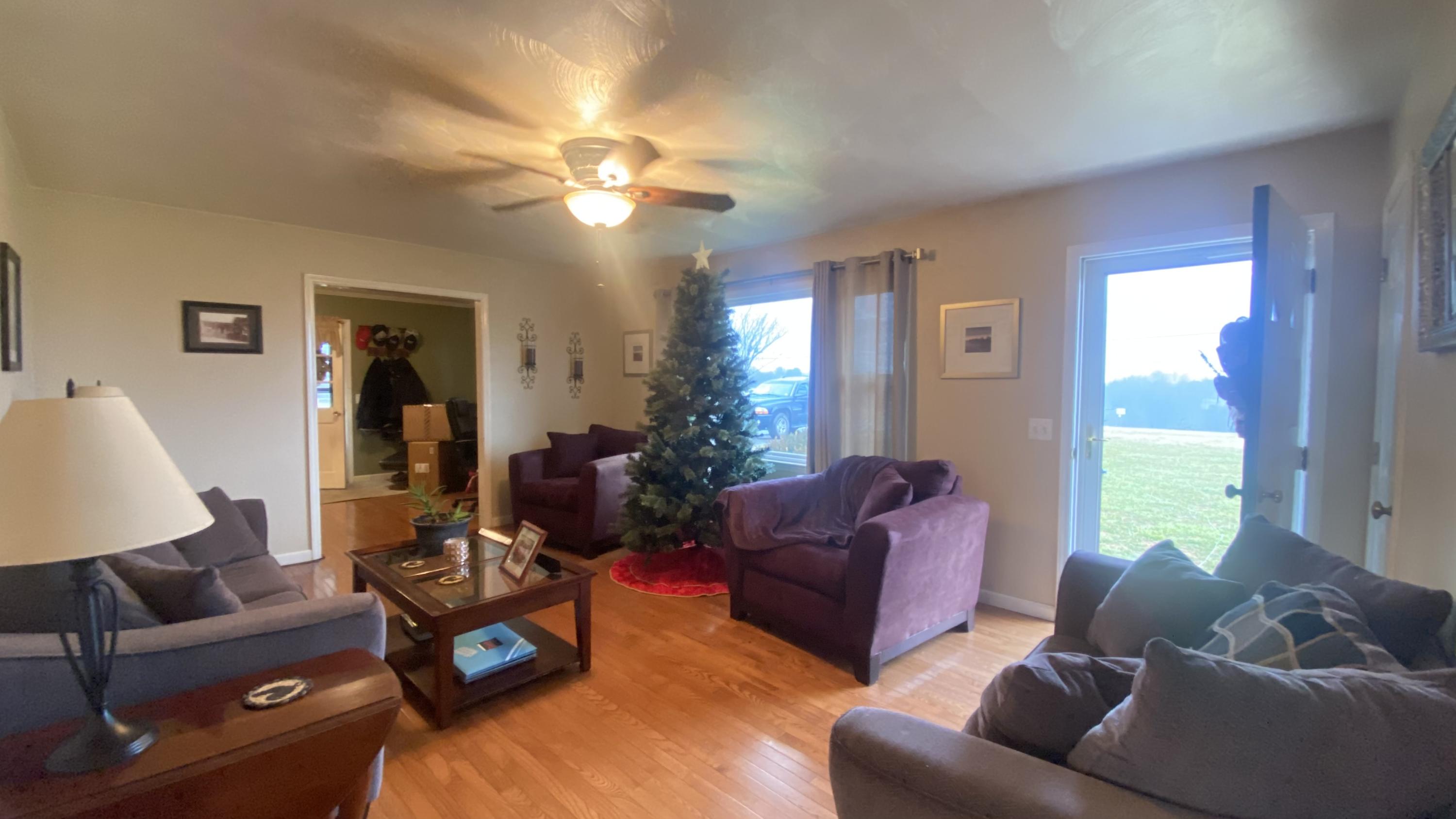 1171 Rock Spring Road Goodview, VA 24095 - Photo 8 of 29 a living room with furniture a large window and a chandelier