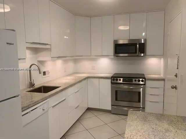 a kitchen with stainless steel appliances granite countertop a sink a stove a microwave and cabinets