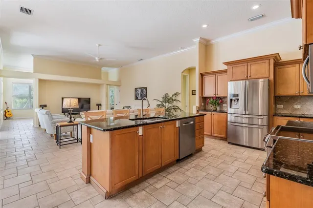 a kitchen with stainless steel appliances a sink counter space and chairs