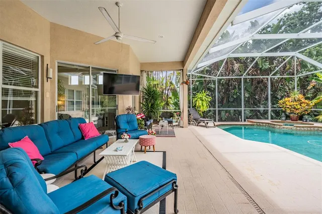a living room with furniture a flat screen tv and a floor to ceiling window