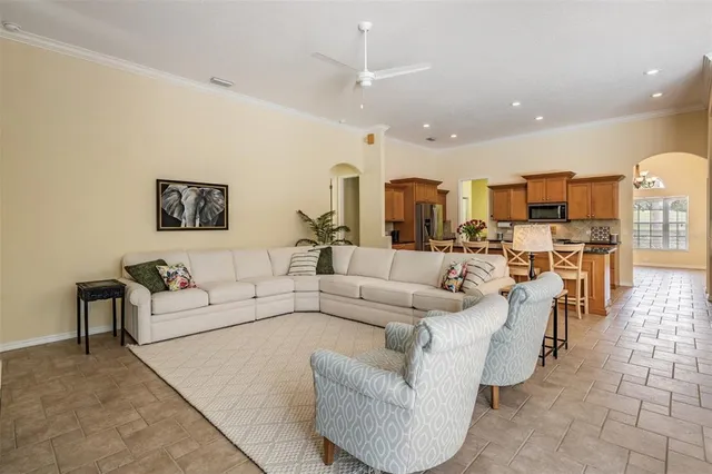 a living room with furniture and view of kitchen