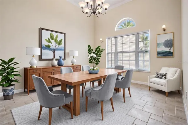 a view of a dining room with furniture a chandelier and a window