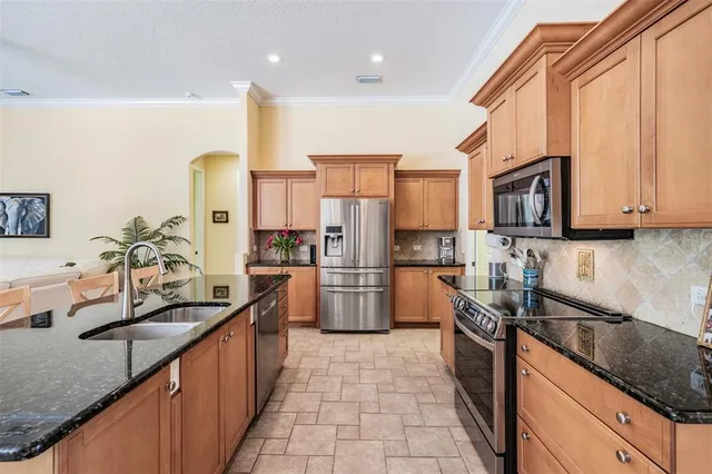 a kitchen with stainless steel appliances granite countertop a sink stove and refrigerator