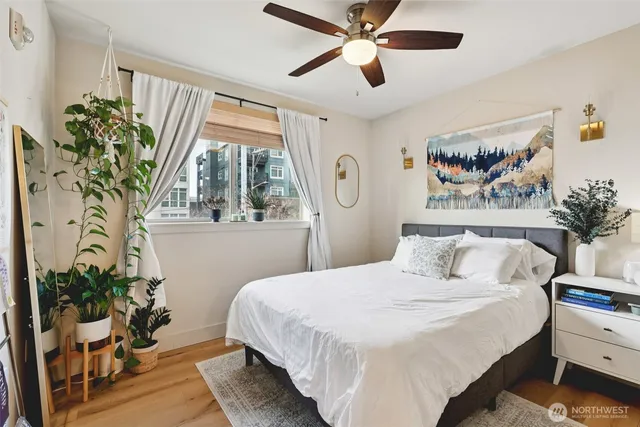 a bedroom with a large bed and a potted plant