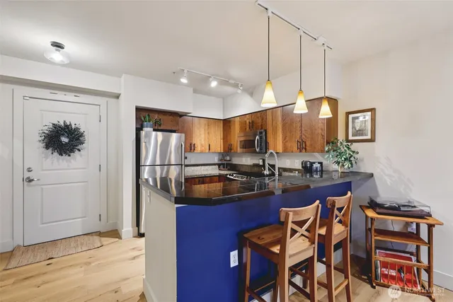 a kitchen with granite countertop a sink cabinets and stainless steel appliances