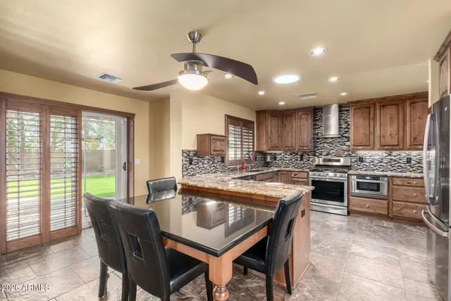 a kitchen with kitchen island granite countertop wooden cabinets and stainless steel appliances