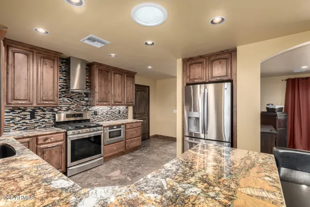 a kitchen with stainless steel appliances granite countertop a stove top oven and sink