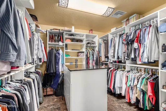 a view of walk in closet with clothes