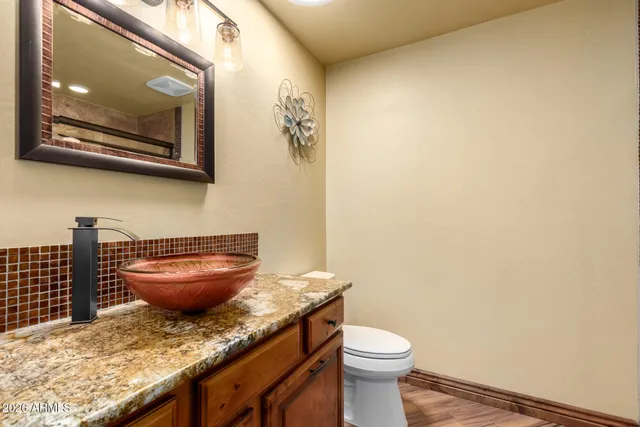 a bathroom with a granite countertop toilet and a sink