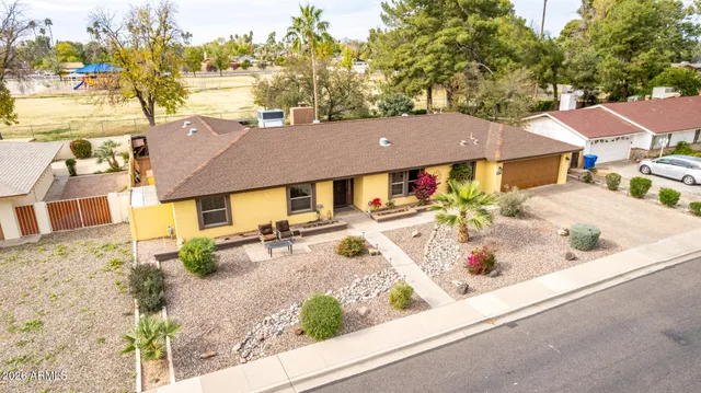 an aerial view of a house with a yard and sitting area