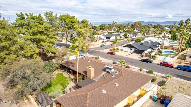 an aerial view of a house with a yard wooden table and chairs