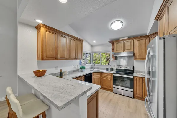 a kitchen with stainless steel appliances granite countertop a sink stove and refrigerator