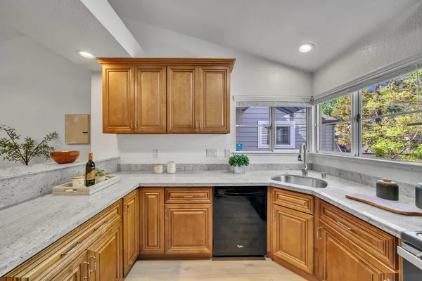 a kitchen with stainless steel appliances granite countertop a sink stove and cabinets