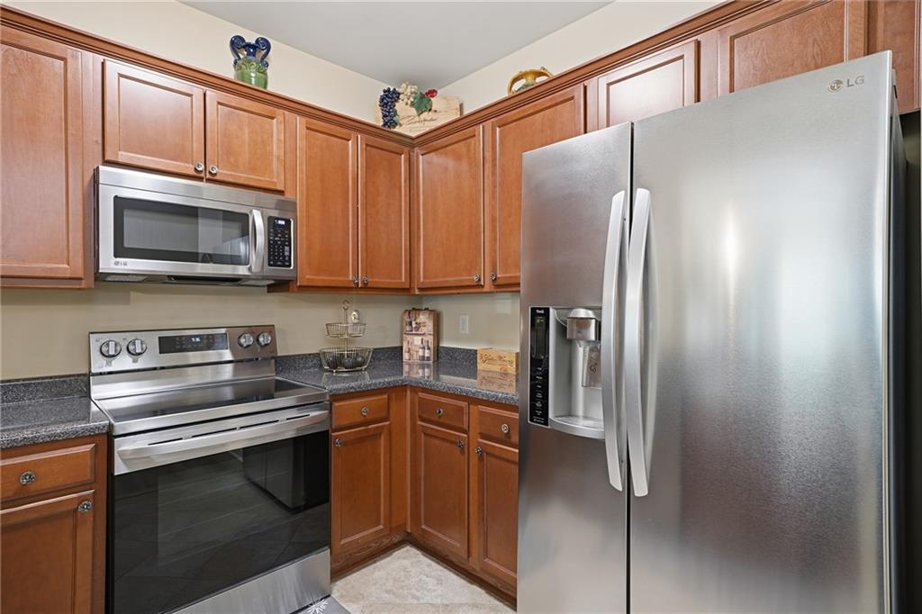 608 Myers Gate Road Ball Ground, GA 30107 - Photo 5 of 31 a kitchen with stainless steel appliances granite countertop a refrigerator stove microwave and sink