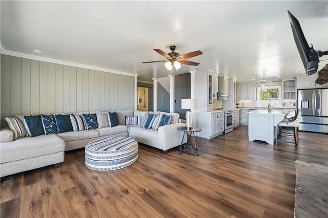 a hallway with hardwood floor and large windows