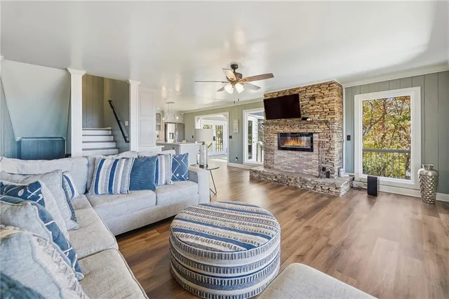 a living room with hardwood floor and large windows