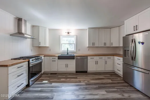 a kitchen with granite countertop white cabinets and stainless steel appliances