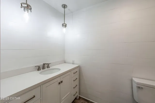 a bathroom with a granite countertop sink a toilet and a shower