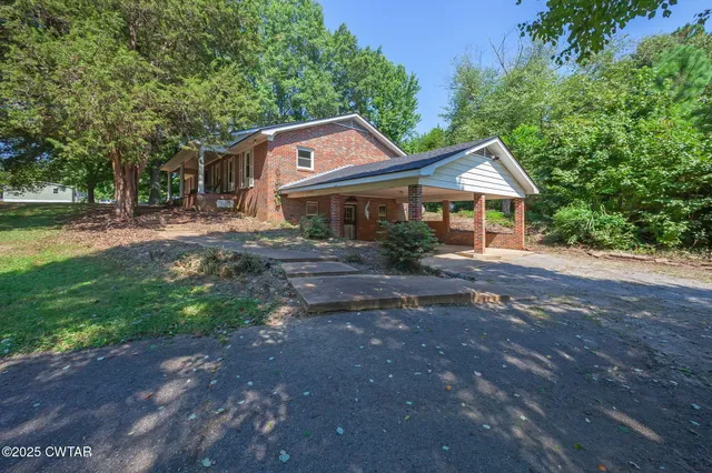 a front view of a house with yard and green space