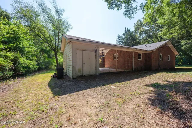 a view of a house with backyard and sitting area