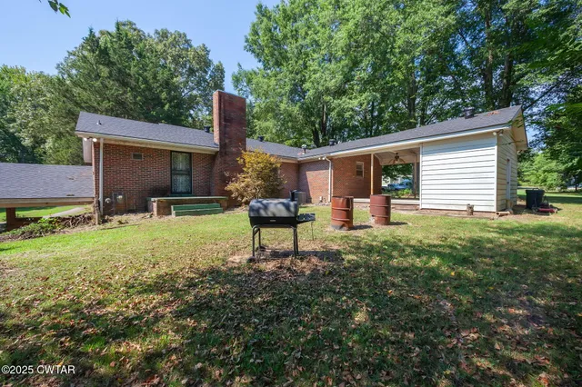 a backyard of a house with yard and trampoline