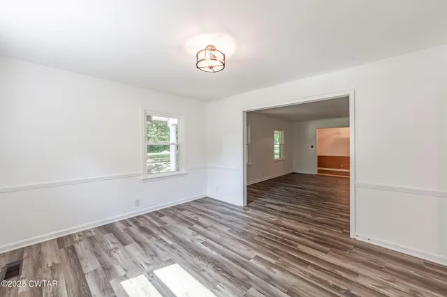 a view of a room with wooden floor and window