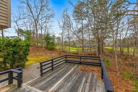 a view of a wooden bench with trees in the background