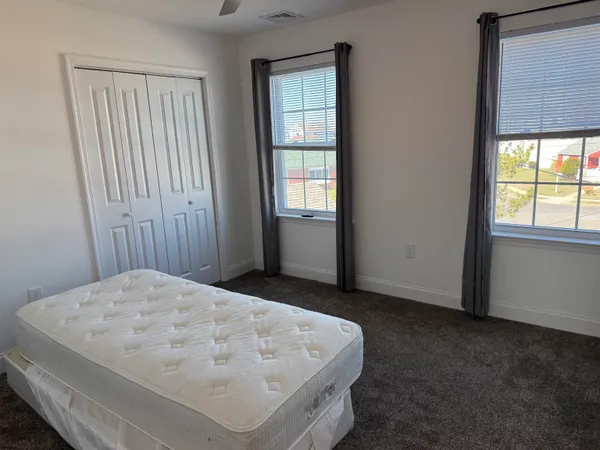 a bed sitting in a bedroom next to a window