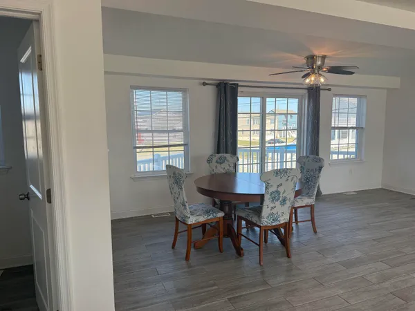 a view of a a dining room with furniture window and wooden floor