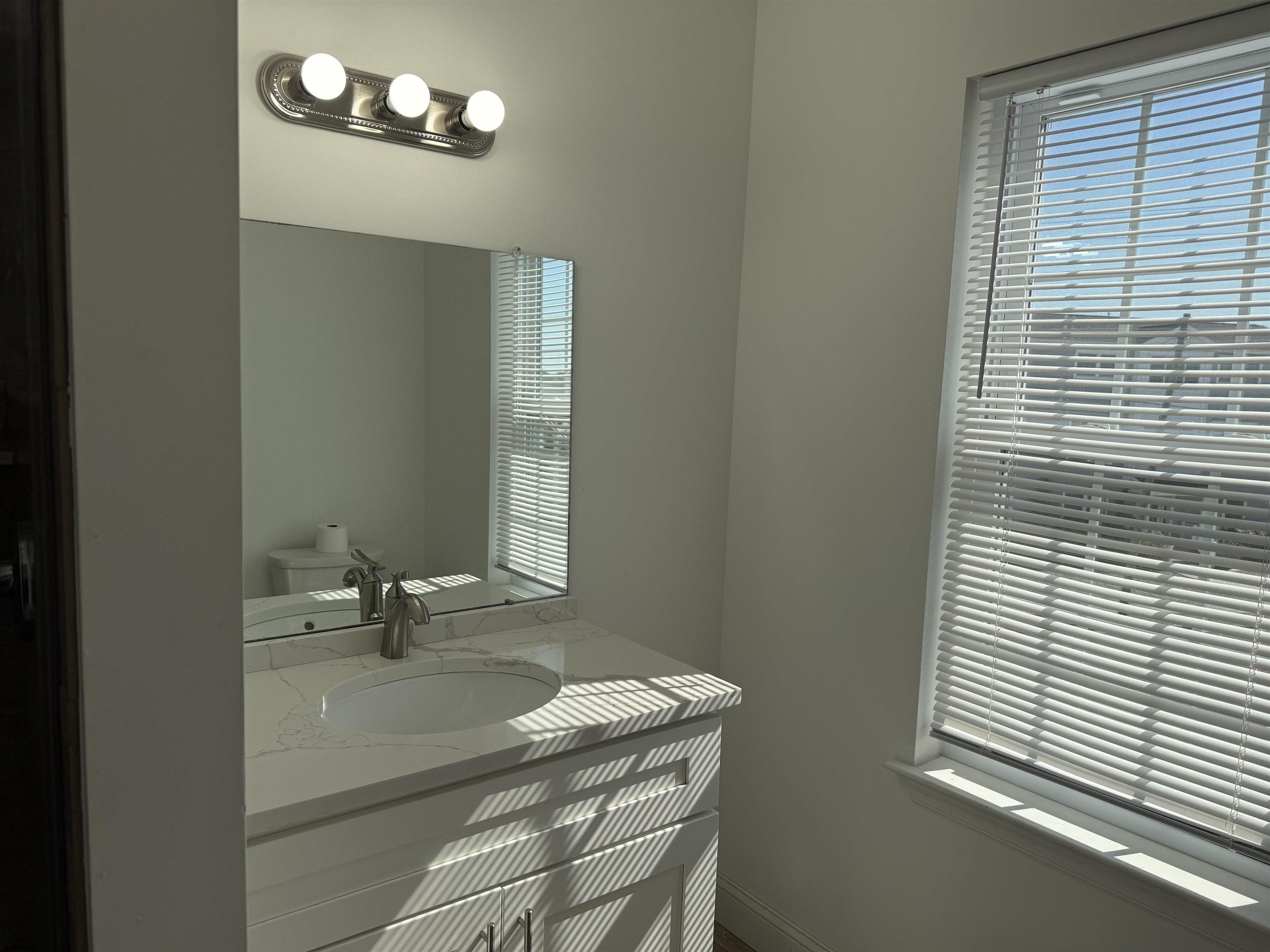 101 West Beach Avenue Brigantine, NJ 08203 - Photo 8 of 11 a bathroom with a sink a vanity and a mirror