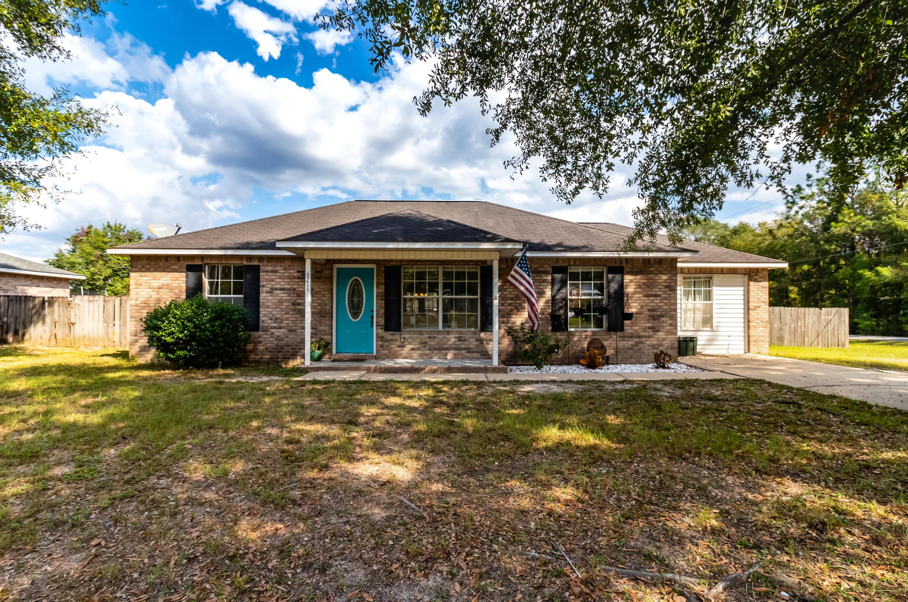 6215 Winstead Road Crestview, FL 32539 - Photo 1 of 11 a front view of a house with a garden and trees