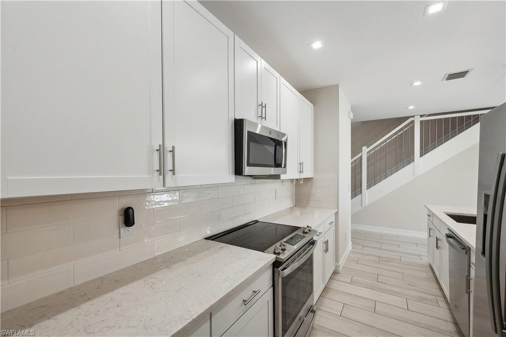 7640 Morgan Way Naples, FL 34119 - Photo 4 of 12 a kitchen with stainless steel appliances granite countertop a sink and a stove