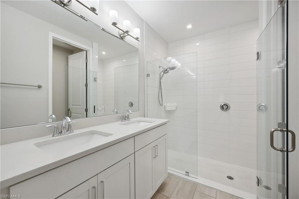 7640 Morgan Way Naples, FL 34119 - Photo 9 of 12 a bathroom with a shower sink double vanity and mirror