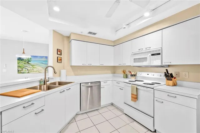 a kitchen with white cabinets appliances and a sink