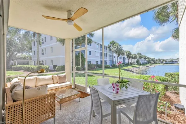a room with patio furniture and a floor to ceiling window