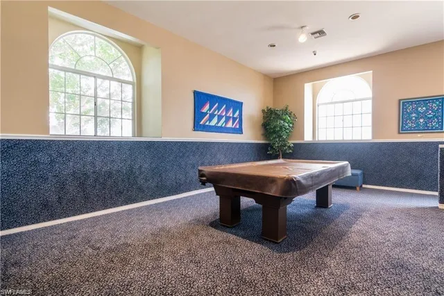 a room with pool table and windows