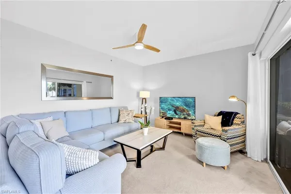 a living room with furniture and a painting on the wall