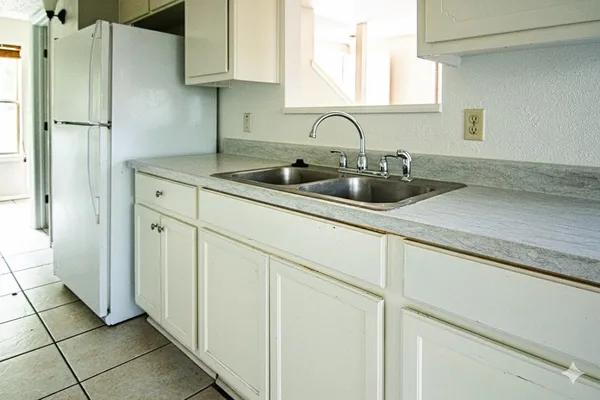 a kitchen with stainless steel appliances white cabinets and a sink