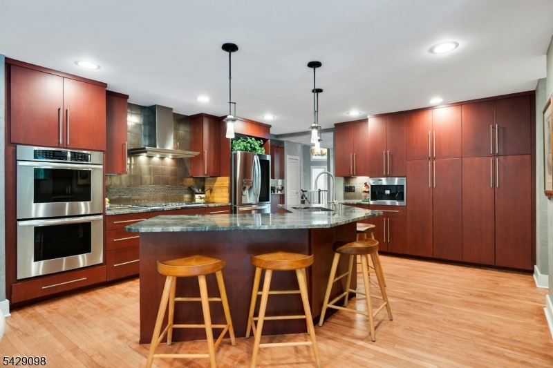 174 Bliss Road Mendham, NJ 07945 - Photo 20 of 49 a kitchen with stainless steel appliances kitchen island granite countertop a refrigerator a stove and a wooden floors