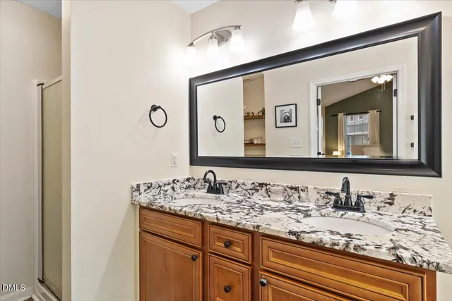 a bathroom with a granite countertop sink and a mirror