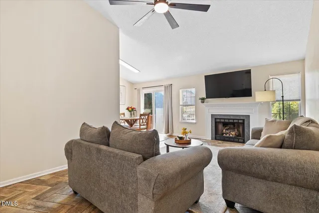 a living room with furniture a fireplace and a flat screen tv